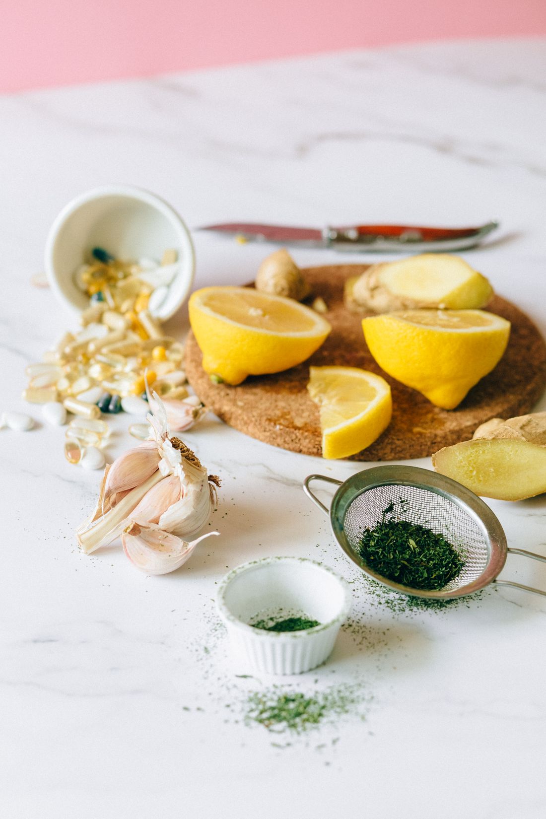 Capsules, gingembre et citron sur un plan de travail en marbre