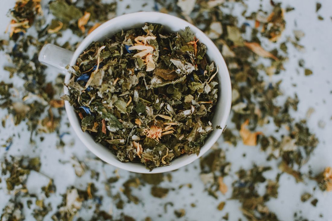 Tasse remplie de plantes séchées pour tisane
