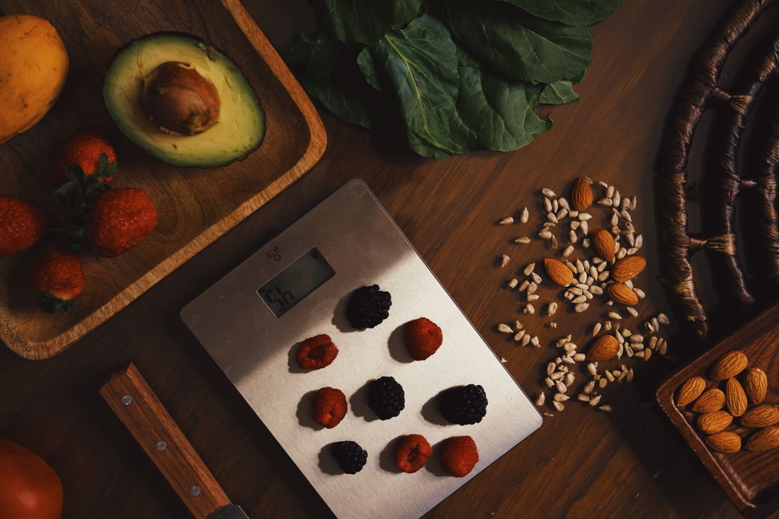 Fruits, baies, amandes et feuilles posés sur une table en bois
